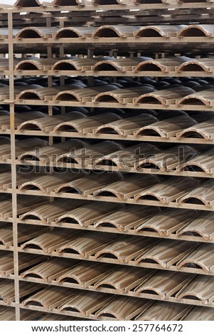 Close up view of a pile of traditional mud roof tile production.