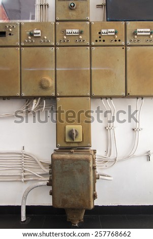 View of old row of electrical boxes on a wall.