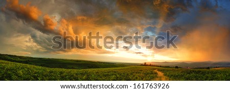 Majestic sunset with storm clouds. Panorama in countryside