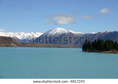 Lake Pukaki - South Island New Zealand. Strange blue colored lake. Snow covered New Zealand Alps in the background.