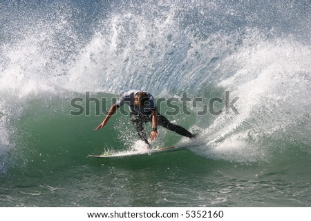 A surfer slashes a turn on a left hand wave.