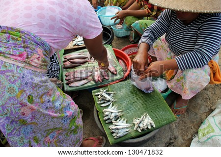 KUTA LOMBOK, INDONESIA - JULY 22 : A woman is selling fish to local customers at Kuta Lombok\'s sunday food market on July 22 2012. The traditional market attracts many from around Kuta Lombok.