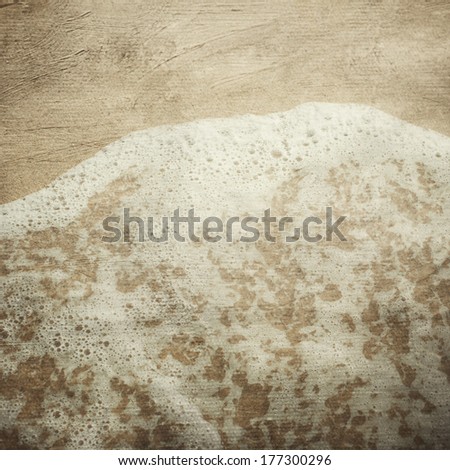 Grunge textured image of sand and sea foam