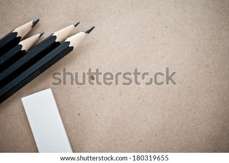 Shabby craft paper background with pencils and eraser
