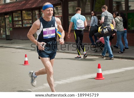 KYIV, UKRAINE - APRIL 28: Senior contender runs smiling during 5-th Wizz Air Kyiv City Marathon, a competition run of 5, 10 and 42 km held in the old city center on April 28, 2013 in Kyiv, Ukraine.