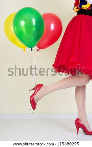 Beautiful female legs in red shoes and balloons, got hold of the heel shoes.