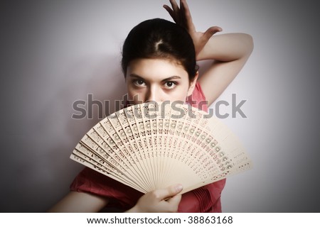 Portrait of the girl in pink to a blouse and a fan in a hand.