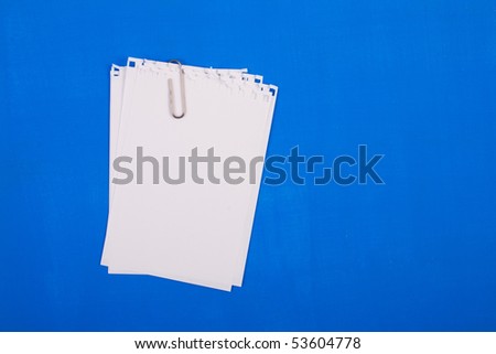 Pure forms fastened by a paper clip on a blue background.