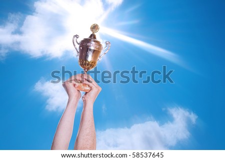 Hand of the person with a sports cup on a background of the bright sky.