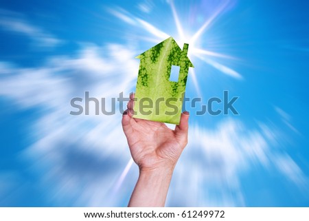 Hand of the person with model the house of the solar sky. Care of an environment.