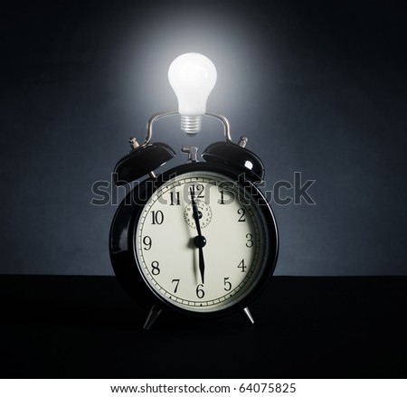 Alarm clock and electric lamp. A symbol of time, new idea and success.