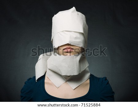 Young woman's head wrapped in paper. Symbol of loneliness and alienation.