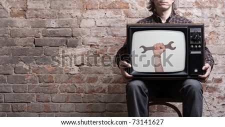 TV with a picture of a wrench in the hands of a seated man .
