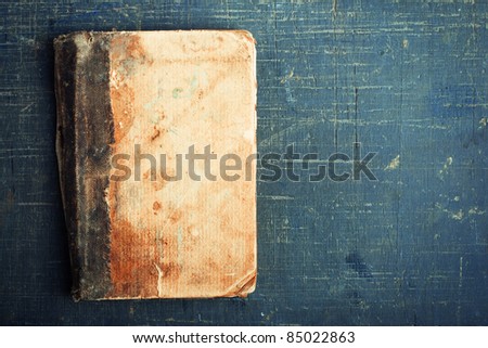 The old, wise book lies on a wooden background