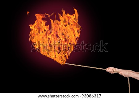 Burning fire heart on a rope holding a pair of hands.