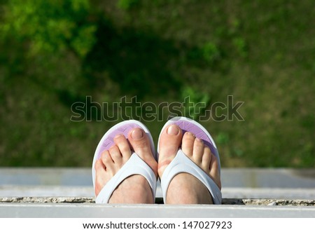 Women's feet in summer shoes.