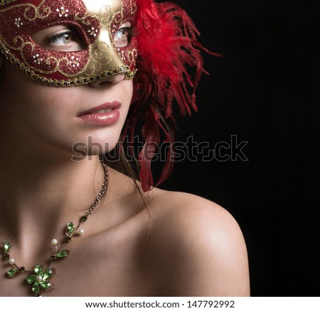 Woman in masquerade mask on a black background.