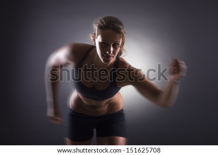 Woman running over dark background