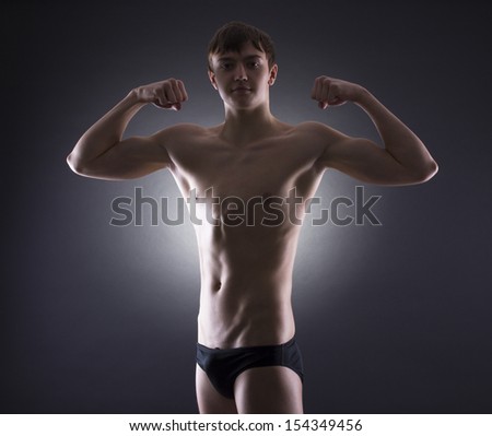 muscular man, black background.