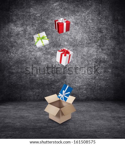 Gift boxes with colored ribbons fall in a large cardboard box.