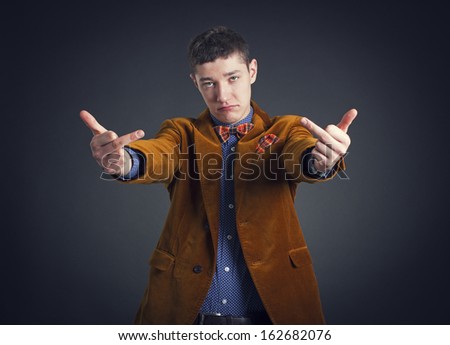 Portrait of a young man with an obscene hand gesture. Middle finger as a sign of aggression - Fuck off.