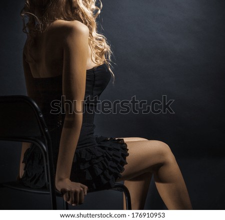 Sitting on a chair in the rough figure of a young woman dress