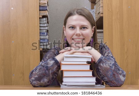 Portrait of clever student with book reading it in college library