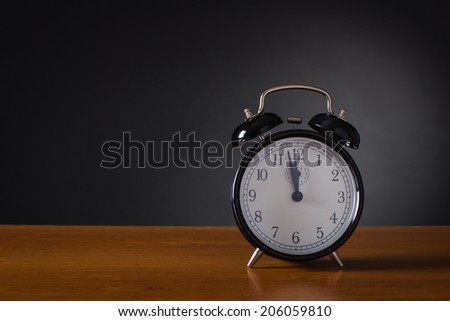 Black alarm clock on a dark background.