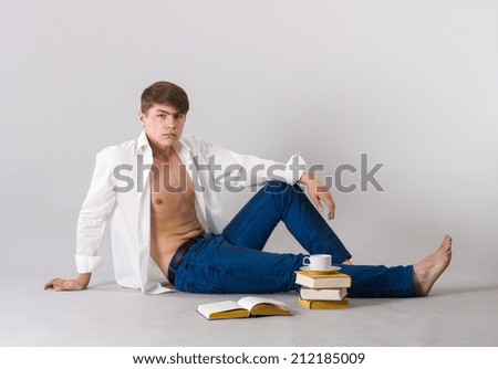 Young man sitting on the floor flipping through the book.