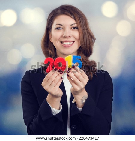 Happy business woman holding a figure of 2015. The symbol of the new fiscal year.