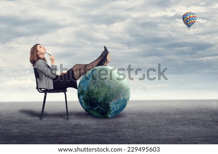 Young businesswoman dreaming sitting on a chair in the open air.