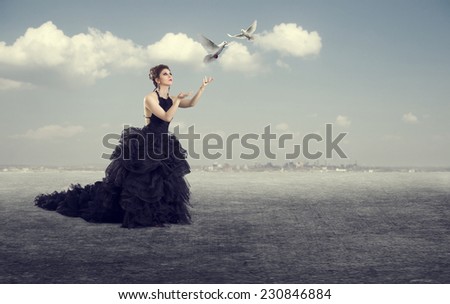 Luxury woman in a long dress of white doves released into the sky.