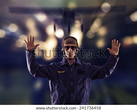 The pilot in uniform on the runway at night.