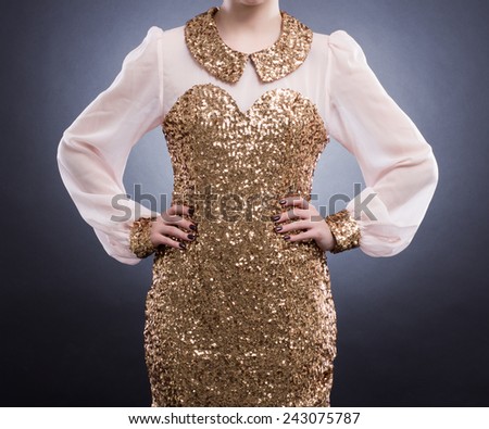 Fashion Image. Beautiful elegant dress with gold sequins on the young woman.