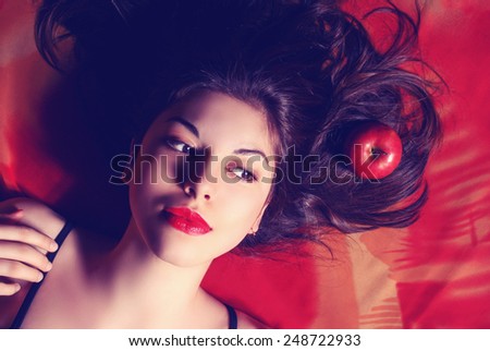 Beautiful young woman with long curly hair and bright makeup. Perfect makeup. Fashion photo