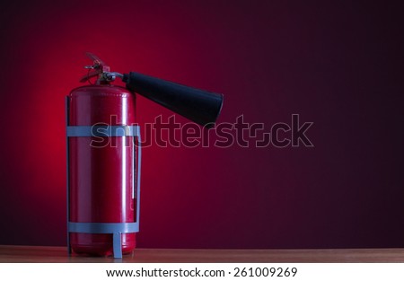 Fire extinguisher on a red background.