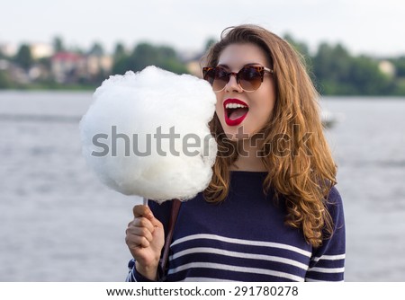 Girl eating cotton candy in the park