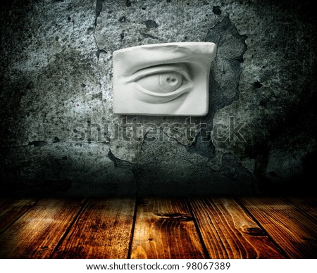 Gypsum eye hangs on the wall of the old interior.