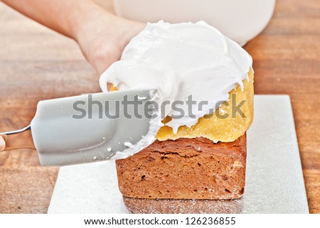 Spreading cream on christmas cake with spatula