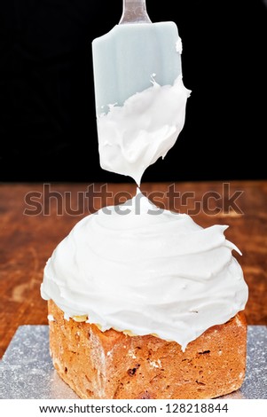 Spreading cream on christmas cake icing with spatula