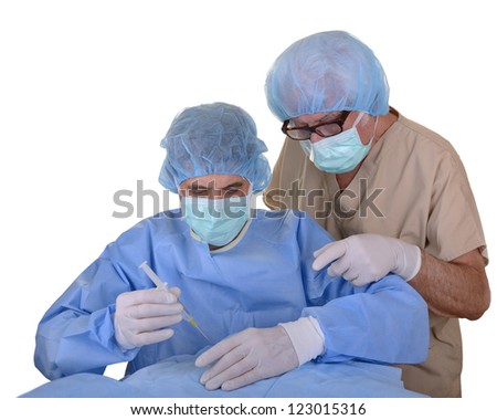 Mature doctor mentoring a young doctor with a needle poised over a patient covered with a sterile drape