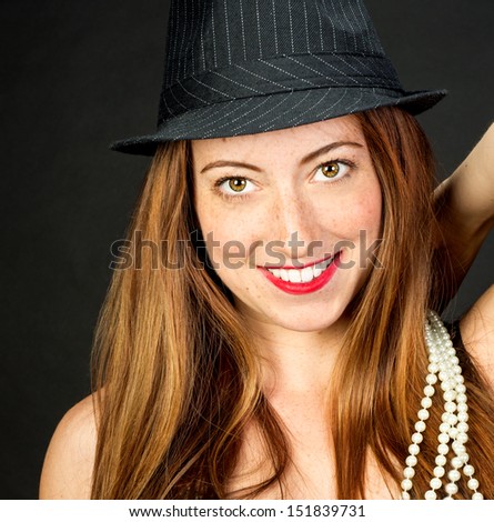 Closeup of adorable red haired woman with beautiful hazel eyes Wearing a fedora smiling