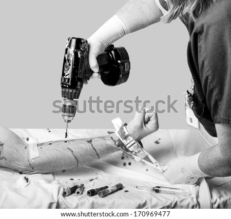 Health care worker holding a patients arm with a restraint using a drill for drawing blood