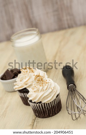 Chocolate cupcakes with vanilla butter cream frosting and gold sprinkles