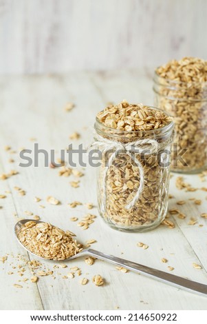 Almond granola in a glass jar with spoon full of granola