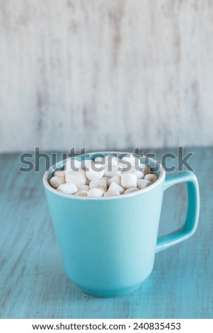 Blue mug of hot chocolate with mini marshmallows in it