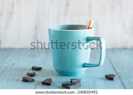 Cup of hot chocolate with broken pieces of chocolate and peppermint stick