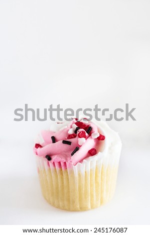 Single Valentines Day cupcake with heart sprinkles on white background