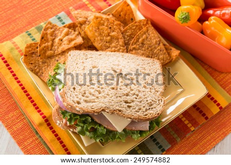 Healthy lunch with ham turkey sandwich with chips and vegetables