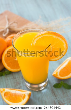 Glass of breakfast orange juice with fresh sliced orange on side of cup